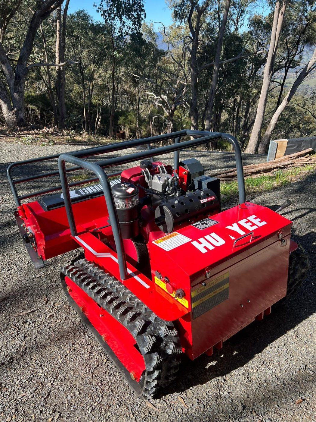 Huayee HYGC1200S remote control mower parked on a gravel trail with bushland behind it